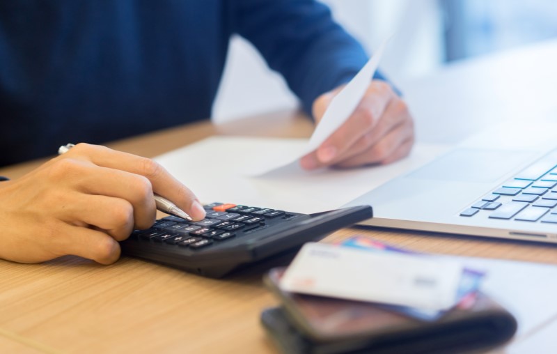 Como calcular o 13° salário | Foto de um homem calculando | Como comprar uma casa | Blog Alea