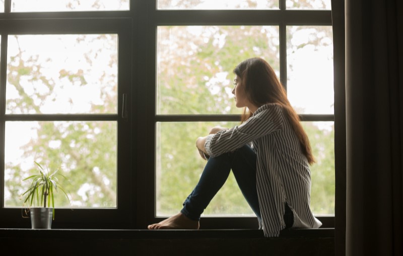 Privacidade em condomínio de casas | Foto de uma moça olhando pela janela de casa | Estilo de Vida | Blog Alea
