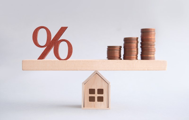 O que é Taxa condominial | Foto de uma casinha de madeira, símbolo da porcentagem e moedas | Estilo de Vida | Blog Alea