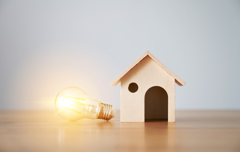 Vantagens da casa pré-fabricada | Foto de uma miniatura de casa de madeira e uma lâmpada acesa | Estilo de vida | Blog Alea