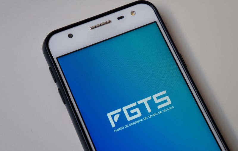 Foto de um celular com o logo do FGTS na tela | Como usar o Saldo do FGTS no financiamento Casa Verde e Amarela | Blog Alea