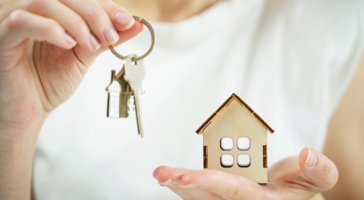Como financiar uma casa | Pessoa segurando chaves e uma miniatura de casa | Como comprar uma casa | Blog Alea