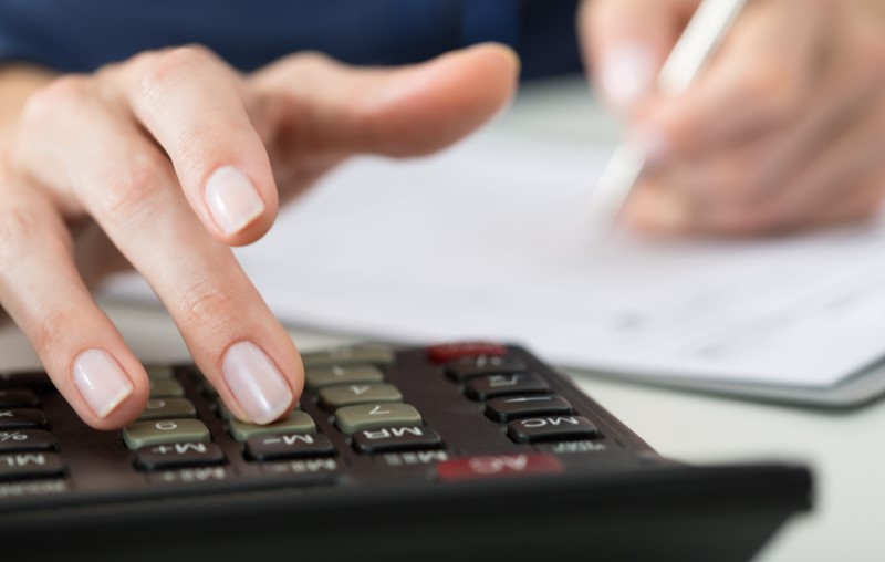 Faça um planejamento financeiro para comprar casa | Foto de uma mulher fazendo contas na calculadora | Blog Alea