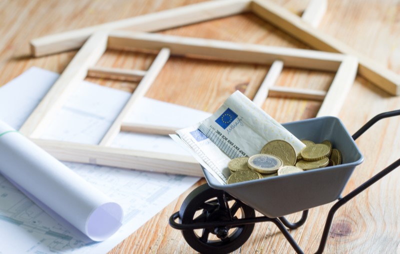 Quanto custa a reforma de uma casa | Foto de uma miniatura de casa de madeira, planta, notas de dinheiro e moedas | Estilo de vida | Blog Alea