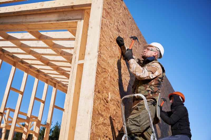 Como funciona a construção de casas em wood frame? | Foto de homens trabalhando em construção no modelo wood frame | Método Construtivo | Blog Alea