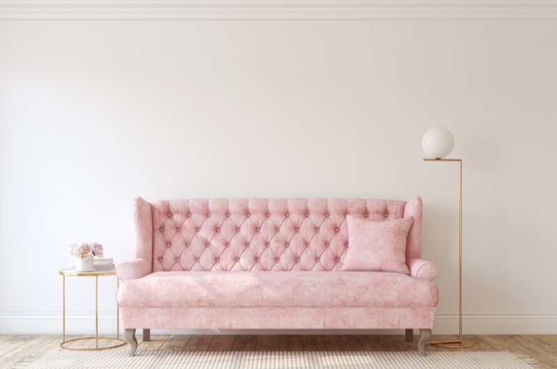 Romântico | Foto de uma sala com estilo romântico, com um sofá em tom rosa pastel, uma mesa de canto e uma luminaria | Estilo de Vida | Blog Alea