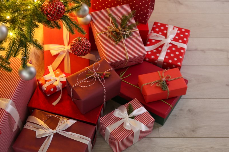 8 dicas para economizar nos presentes de Natal | Foto de diversos presentes no chão, ao redor da árvore de Natal | Estilo de Vida | Blog Alea 