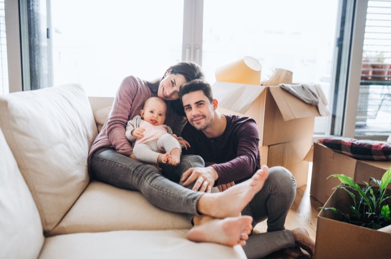 Caçapava | Foto de uma família com um bebe recém nascido, reunidos no sofá da sala | Estilo de Vida | Blog Alea