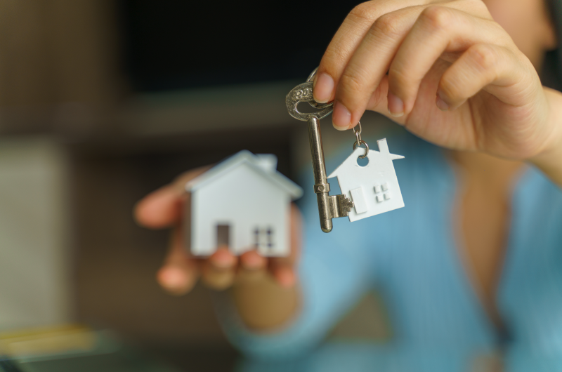 O que levar em conta antes decidir entre comprar ou alugar uma casa? | Foto de uma pessoa segurando uma casinha e uma chave | Como comprar uma casa | Blog Alea